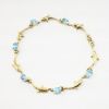 Picture of 14k Yellow Gold & Oval Cut Blue Topaz Bracelet with Dolphin Shaped Links